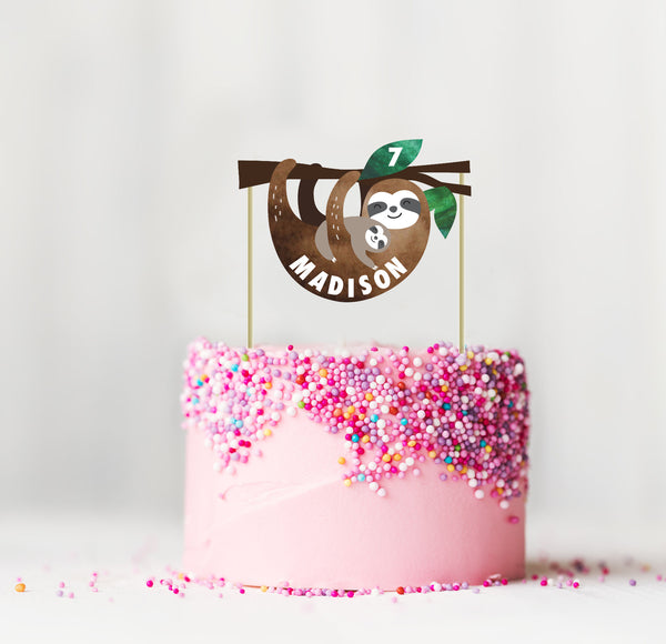 sloth cake topper on a pink cake with sprinkles